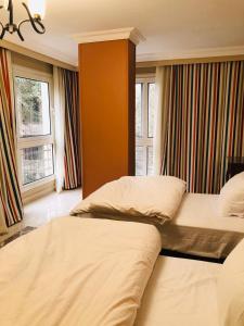 - 2 lits dans une chambre d'hôtel avec fenêtres dans l'établissement المنيل -شقة مفروشة للإيجار 5 نجوم - بارقي احياء القاهرة -, au Caire