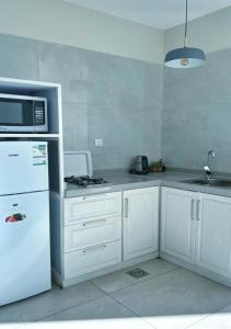 a kitchen with a white refrigerator and a microwave at بيات للنزل السياحية in Al Qarāḩīn