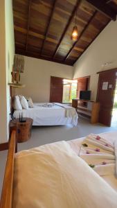a hotel room with two beds and a television at POUSADA RANCHO PARAISO in Pôrto de Pedras