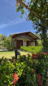 a house with a garden with flowers in front of it at POUSADA RANCHO PARAISO in Pôrto de Pedras