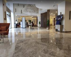duży hol z żyrandolem w budynku w obiekcie Gloria Hotel & Suites Doha w mieście Doha