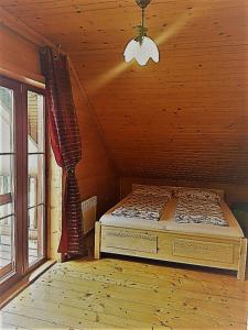 ein Schlafzimmer mit einem Bett in einem Zimmer mit einem Fenster in der Unterkunft Rozprávkový zrub in Dúbrava