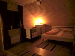 ein kleines Zimmer mit 2 Betten und einer Lampe an der Wand in der Unterkunft Rozprávkový zrub in Dúbrava