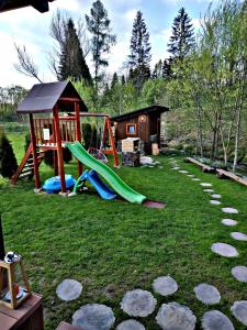 une aire de jeux avec toboggan et une maison dans l'établissement Rozprávkový zrub, à Dúbrava