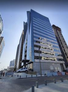 un edificio alto con un coche aparcado delante de él en Gloria Hotel & Suites Doha, en Doha