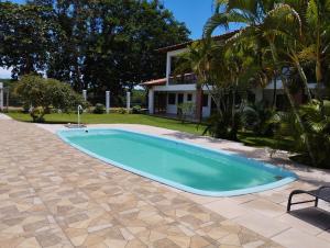 a swimming pool in a yard with a house at Pousada São Nunca in Ilha de Comandatuba