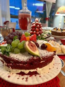 um bolo com fruta num prato numa mesa em Vivas Hotel e Casa em Monte Sião