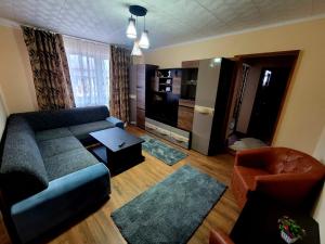a living room with a couch and a tv at Apartament Bia in Lupeni