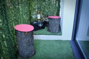 a table with a bottle of wine and two tree stump tables at Lasuite55 in Istres