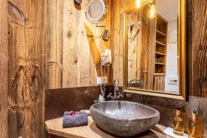 La salle de bains est pourvue d'un grand lavabo en pierre sur un comptoir en bois. dans l'établissement Chalet Hüttentraum, à Inzell