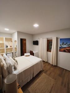 um quarto com uma grande cama branca e uma janela em Beach Eco Stays Hotel Boutique Lagoinha em Paraipaba