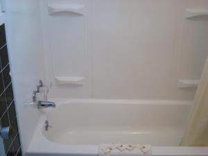 a bathroom with a white tub and a sink at Gray Plaza Motel in Benton
