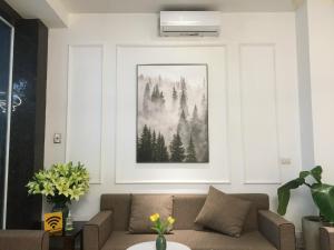 sala de estar con sofá y una foto en la pared en Keypad - Saki Hotel - 28 Dịch Vọng Hậu, Cầu Giấy en Hanói