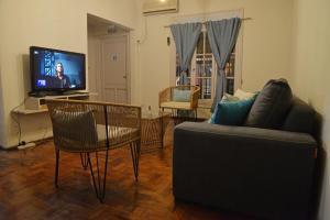 ein Wohnzimmer mit einem Sofa und einem TV in der Unterkunft HOSTEL KUYUK in Mendoza