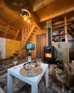 a room with a table with wine glasses and a stove at Cottage Angel in Žabljak