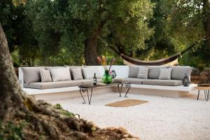un divano bianco e un tavolino in un parco di TRULLO TIPOTA with private pool a Ceglie Messapica