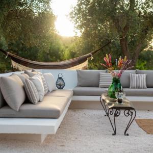 un soggiorno con divano e tavolo di TRULLO TIPOTA with private pool a Ceglie Messapica