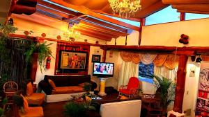een woonkamer met een bank en een tv bij Hotel Maderanegra By Huasicama in Latacunga