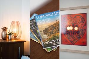 zwei verschiedene Bilder von Büchern und eine Lampe auf dem Tisch in der Unterkunft Mariner's Belle in St Ives