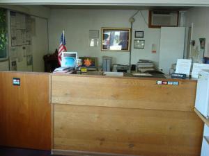 Um balcão de escritório com uma bandeira americana em cima. em Gray Plaza Motel em Benton