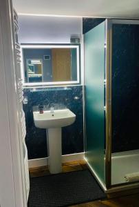La salle de bains est pourvue d'un lavabo et d'une douche. dans l'établissement Skye View Cottage, à Portree