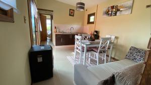 eine Küche und ein Esszimmer mit einem Tisch und Stühlen in der Unterkunft Cabañas Las Terrazas De Iculpe in Lago Ranco
