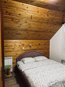 a bedroom with a wooden ceiling with a bed at Apartments Anđela in Žabljak