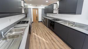 a kitchen with stainless steel appliances and wooden floors at Lovely homely studio available in Birmingham