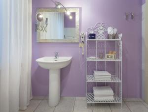 a purple bathroom with a sink and a mirror at B&B Maison Biagetti in Santarcangelo di Romagna