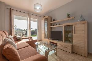 ein Wohnzimmer mit einem Sofa und einem TV in der Unterkunft Casa Carmen in Estepona