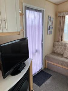 ein Wohnzimmer mit einem TV und einem Sofa in der Unterkunft Ingoldmells - Millfields D13 in Ingoldmells