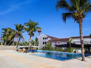 a swimming pool next to a building with palm trees at Home at 9 in Ban Klang (4)