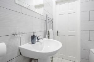 a white bathroom with a sink and a shower at TMS Top Flat! Tilbury! in Tilbury