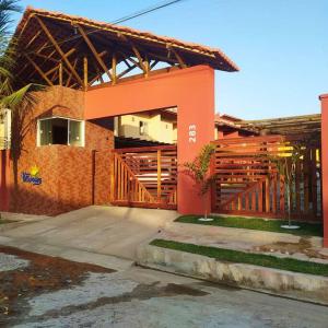 une maison en briques avec une balustrade en bois devant elle dans l'établissement Condomínio Villamares, à Luis Correia