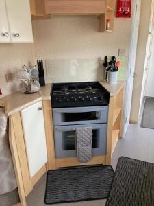 a small kitchen with a stove in a kitchen at Ingoldmells - Millfields D13 in Ingoldmells