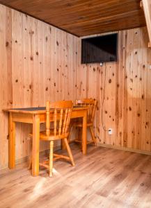 a dining room with a wooden table and chairs at Domek Wakacyjna in Augustów