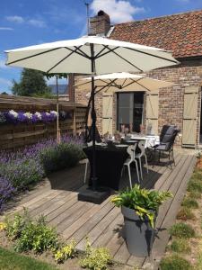 a patio with a table and an umbrella at CasaDeKaMa in Evergem