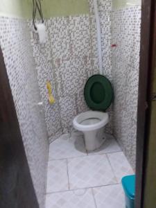 ein Badezimmer mit einem WC mit grünem Sitz in der Unterkunft EL CALEUCHE in Rio das Ostras