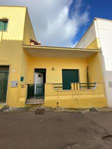 ein gelbes Haus mit einem Tor und einem Balkon in der Unterkunft Casa Da Simone in Melissano
