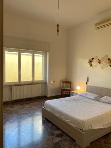ein Schlafzimmer mit einem großen Bett und zwei Fenstern in der Unterkunft Casa Da Simone in Melissano