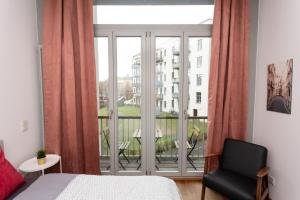 a bedroom with a bed and a window with a balcony at FULL HOUSE Premium Apartments Leipzig M14 in Leipzig