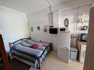 a small bedroom with a bed and a refrigerator at Nicosia rooms Studios in Nicosia