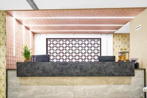 a lobby with a reception desk with two chairs at Treebo Trend Madhuvan Grand in Vijayawāda