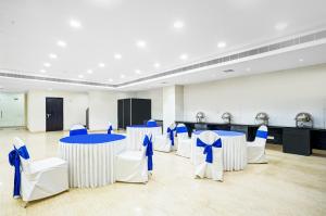 une salle de banquet avec des tables et des chaises bleues et blanches dans l'établissement Treebo Trend Madhuvan Grand, à Vijayawada