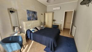 a bedroom with a blue bed and a blue chair at Marifra Flats in Taormina