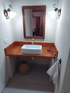 a bathroom with a sink and a mirror at Solar dos Tios in São Thomé das Letras