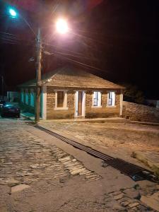 a building on a street at night with a street light at Solar dos Tios in São Thomé das Letras +7 photos