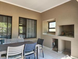 a dining room with a table and chairs and a fireplace at 3714 @Ribbok in Marloth Park