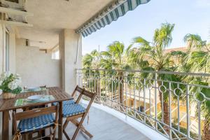 a balcony with a table and chairs and palm trees at Salamanca 10 Relax Time in Santa Pola