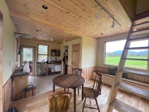 uma cozinha e sala de estar com mesa e cadeiras em 小さな森の貸し切り宿Forest-House-Ranapirica em Shibetsu